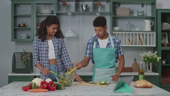 Positive African American Couple Playing While Cooking in Kitchen