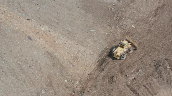 City Dump. The Bulldozer Moves Along the Landfill, Leveling the Garbage.