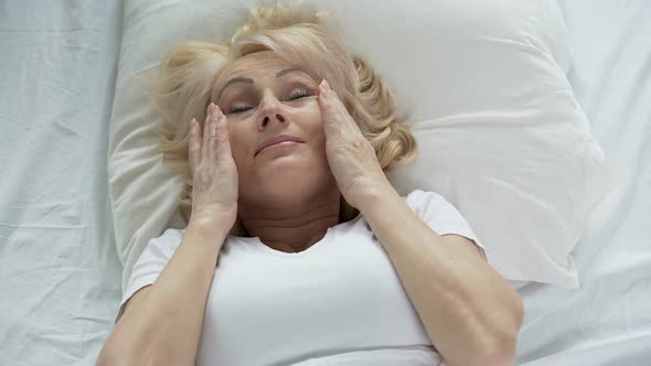 Blond Senior Woman Waking Up and Touching Her Face, Mask Effect, Skincare