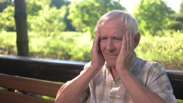 Elderly Man Holds His Head