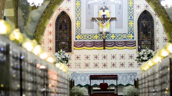 Truck caption through the aisle of a church altar with jesus cross behind it. Blurred foreground. Th