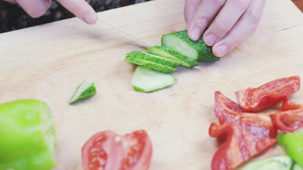 Woman Cutting Fresh Cucumber