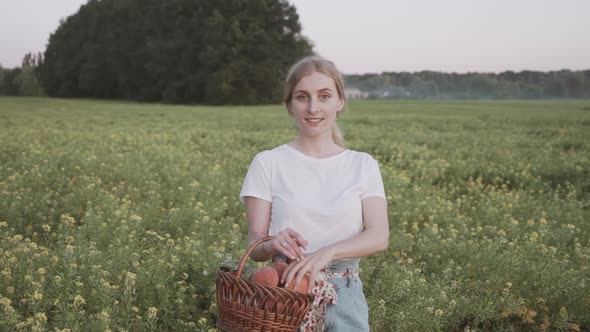 A Beautiful Country Side Girl Holding a Basket of Ripe Peaches. Organic Farming Fruits