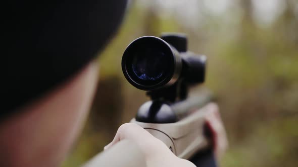 Hunter aiming for wildlife. Close up of hunter aiming down his rifle in autumn season