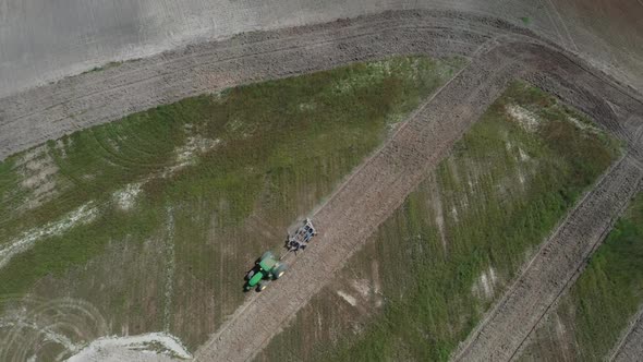 A tractor plowing fields from deforested land in the Brazilian savannah - straight down aerial view