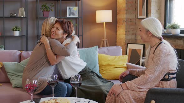 Three Mature Girlfriends Hugging during Home Party