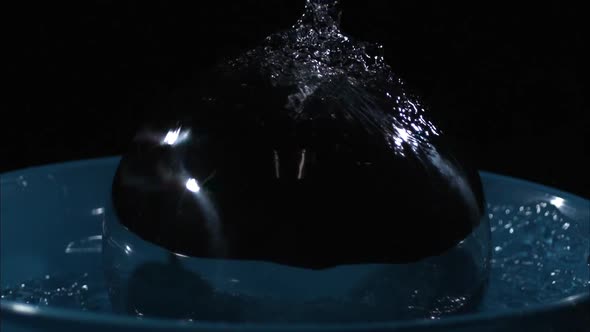 Slow motion of chrome ball being dropped in to water.