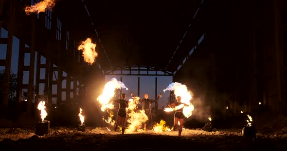 Four Women in Leather Clothes with Fire Dance and Show Fire Show a Man with a Flamethrower in the