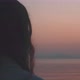 Back view of a woman staring at the sunrise over the sea - VideoHive Item for Sale