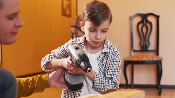 Father teaching son to use screwdriver