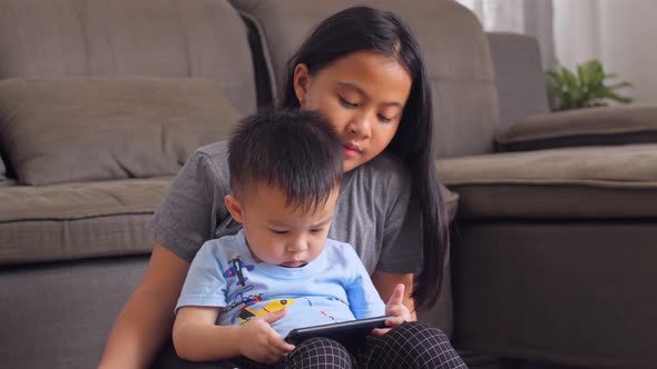 Sister And Her Brother Watching On Mobile Phone