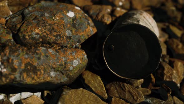 Rusty Destroyed Metal Barrel on Beach Rocks