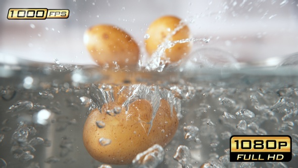 Unpeeled Potatoes Falling into Pot with Boiling Water