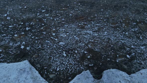 Panning Left Ice Drifting During Windy Weather with Waves at Sea Top Down Aerial View