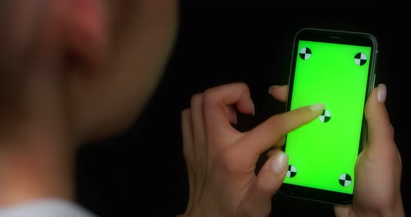 Woman Using Mobile App on Green Screen Phone Swipes Up