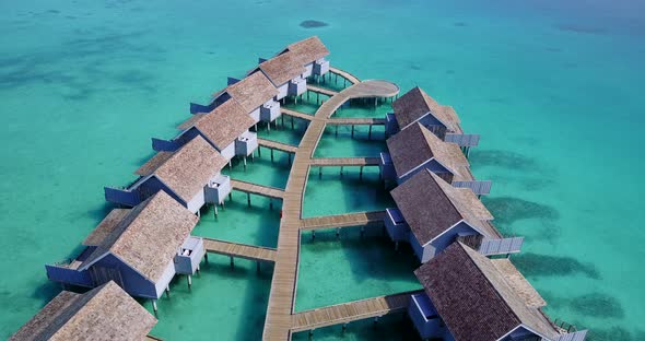 Wide angle above clean view of a sandy white paradise beach and aqua blue ocean background in vibrant