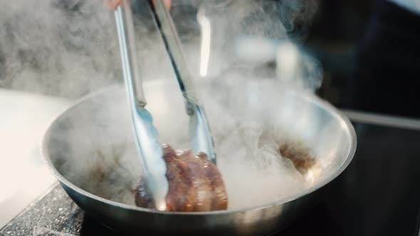 Close-up of a filet mignon being cooked in a frying pan