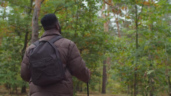 African Hiker with Backpack Travelling in Forest