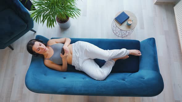 Woman in Wireless Headphones Listening to Music and Using Mobile Apps or Communicates on Social