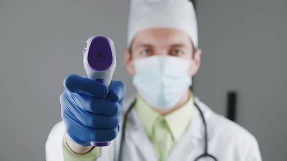 Blurred Silhouette of a Male Doctor in a Dressing Gown and a Mask