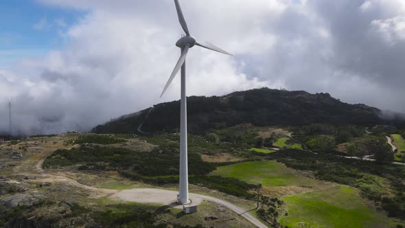 Wind turbine for eolic energy production on green mountain of Caramulo, Portugal. Aerial pedestal up