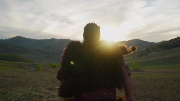 Man Wearing Fur Clothes with Leather Belt Runs Along Valley