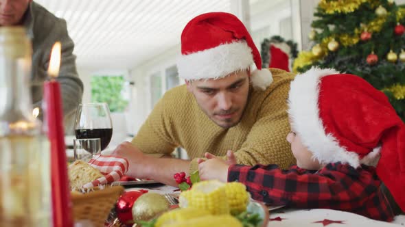 Caucasian father and son talking at christmas table