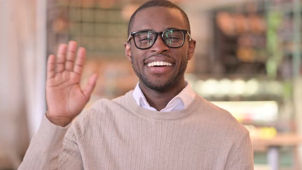 Portrait of Cheerful African Man Waving at the Camera 