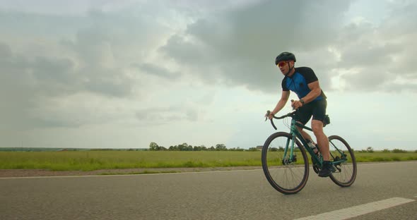 The Cyclist is Riding Along the Highway and Increasing Speed