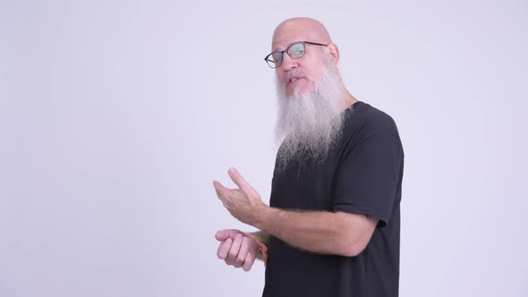 Happy Mature Bald Bearded Man Presenting and Showing Something