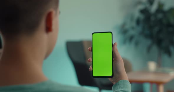 Man Holding Smartphone with Green Mock Up Screen