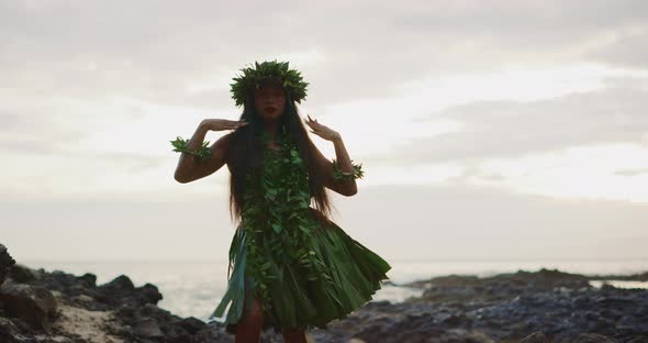 Woman performing traditional Hawaiian hula by the ocean alt
