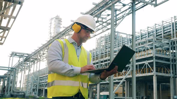 Refinery Worker with a Laptop on the Plant Premises