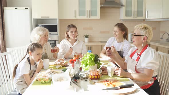 Friendly Caucasian Family Drinking Tea and Having Happy Time Together at Home in Kitchen