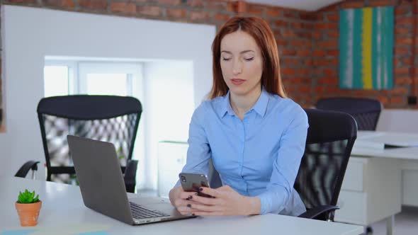 Businesswoman Using Her Mobile Phone in the Office