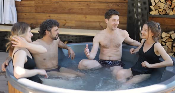 Friends Having Fun Bathing at Spa Outdoors