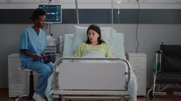 Sick Woman Adult Resting in Bed While Black Nurse Analyzing Disease Expertise