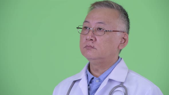 Face of Happy Mature Japanese Man Doctor Thinking