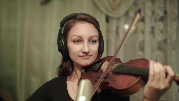 The Musician with Headphones Rehearsing Instrumental Melody with Violin at Notes