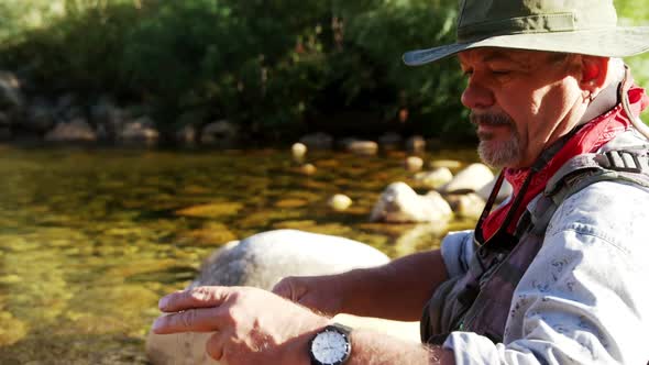 Fly fisherman putting new string on fishing rod