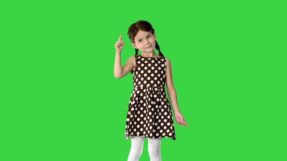 Little Girl in Polka Dot Dress Dancing and Raising Her Arms on a Green Screen Chroma Key