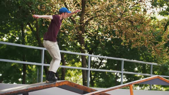 Aggressive Inline Roller Skater Doing Tricks in Concrete Skatepark Outdoors with Beautiful