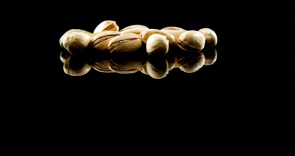 Pistachios falling on black background 4k