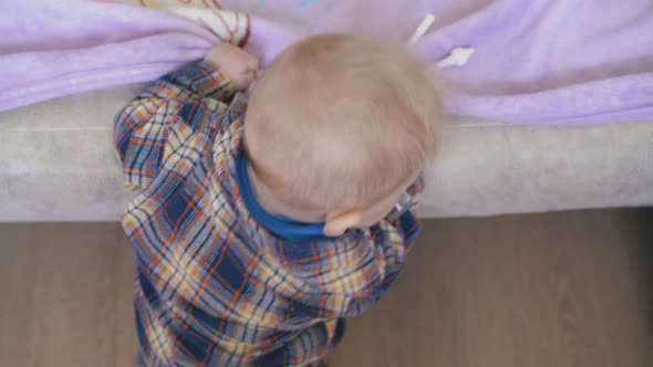 Active Boy with Aspirator Climbs Up on Soft Bed in Room