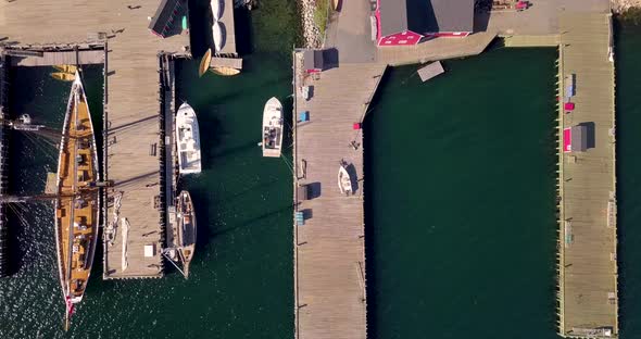 Aerial footage of sailboats and tall ships docked in the harbor at Lunenburg, Nova Scotia, Canada