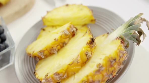 Slices and halved pineapples in plate