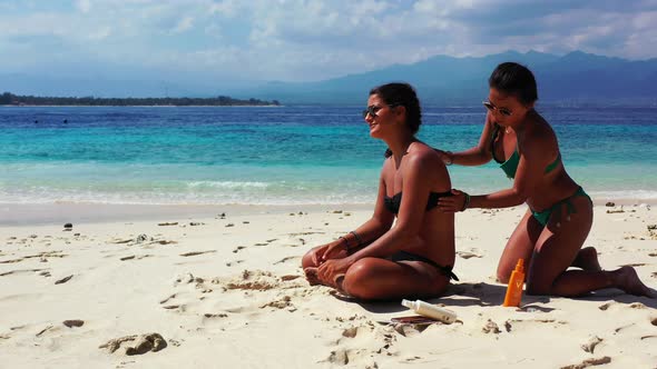 Sexy happy ladies on holiday by the sea on beach on summer white sand and blue background 