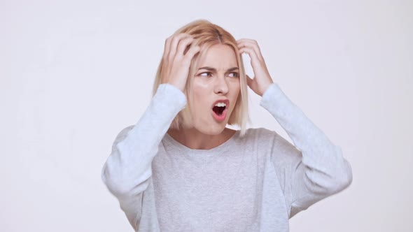 Young Beautiful Upset Blonde Girl in Anger Over White Background