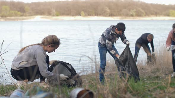 People Collecting Garbage Near the Lake