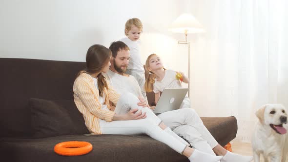 Friendly Caucasian Family at Home with Laptop